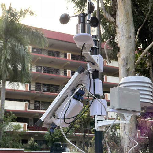 White printed enclosures and mounts arranged on an outdoor monitoring mast