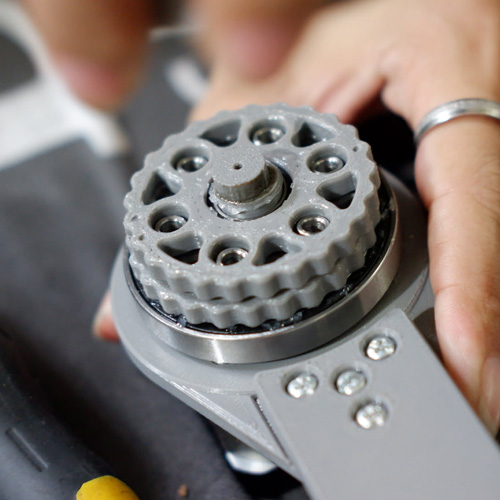 Close-up of the printed geared joint and metal bearing where the robot arm meets its base